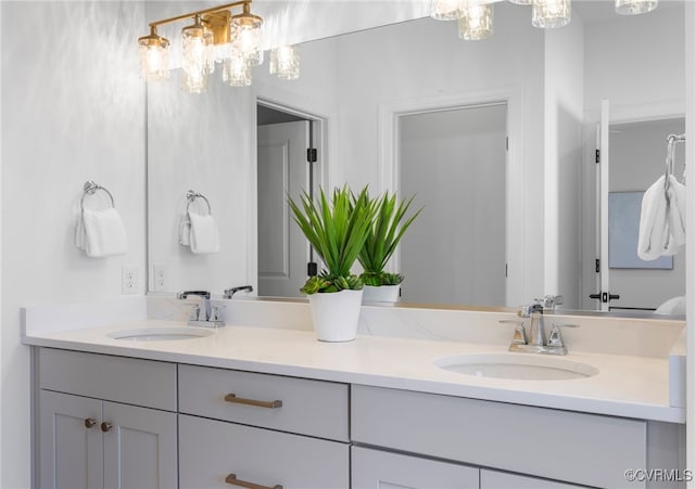 full bathroom featuring double vanity, a sink, and a chandelier