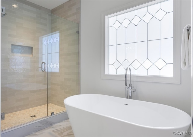 bathroom featuring marble finish floor, a sink, a shower stall, and a soaking tub