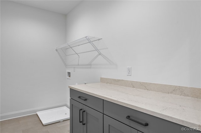 washroom featuring cabinet space, washer hookup, and baseboards