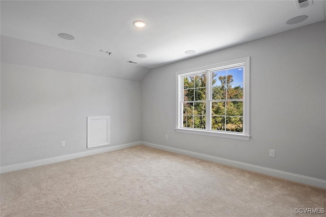 empty room featuring baseboards, carpet flooring, and vaulted ceiling