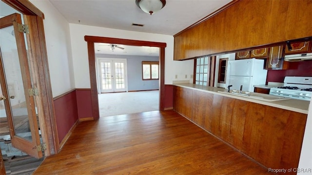 4506 Hickory Fork Rd, Gloucester Point, VA 23061 - kitchen with a sink, visible vents, under cabinet range hood, wood finished floors, and white appliances