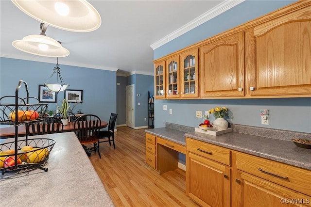 13032 Beech Creek Ln, Ashland, VA 23005 - kitchen featuring light wood-type flooring, crown molding, glass insert cabinets, hanging light fixtures, and brown cabinetry