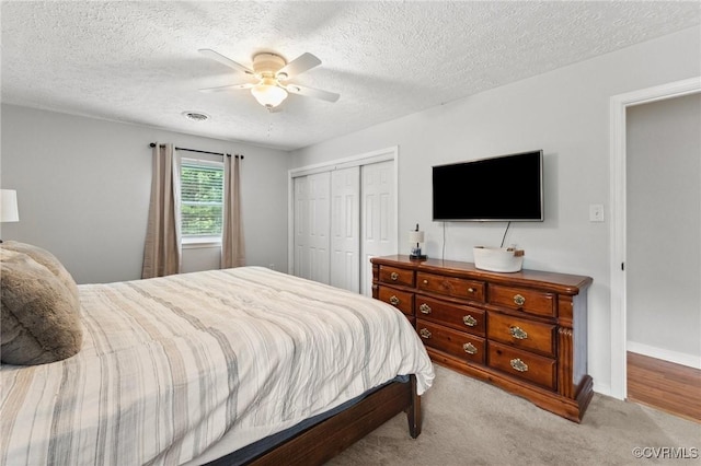 bedroom featuring carpet, a closet, visible vents, a ceiling fan, and a textured ceiling