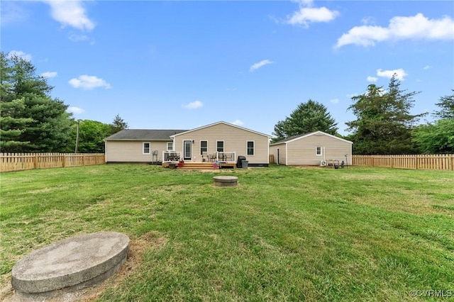 rear view of property featuring a deck, a yard, and a fenced backyard