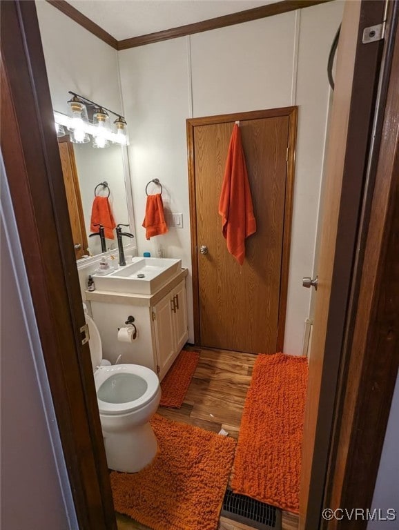 116 Sycamore Ct, Bracey, VA 23919 - half bath with ornamental molding, vanity, toilet, and wood finished floors