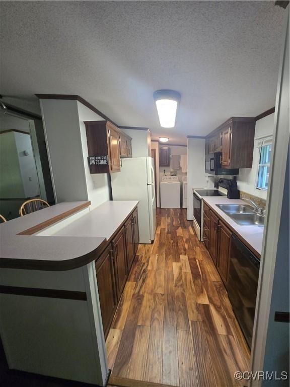116 Sycamore Ct, Bracey, VA 23919 - kitchen featuring a sink, dark wood-style flooring, washer and dryer, freestanding refrigerator, and electric range