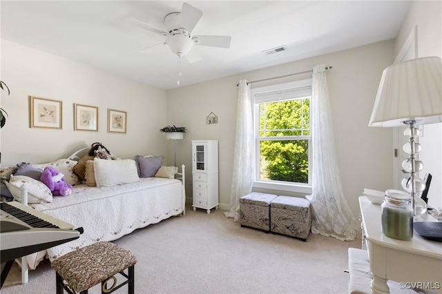 carpeted bedroom with a ceiling fan and visible vents