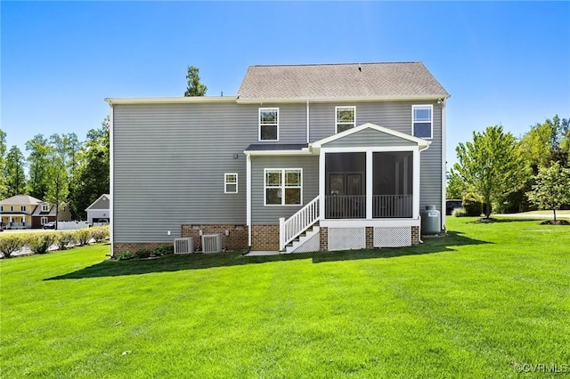 back of property featuring a lawn, a sunroom, and central air condition unit