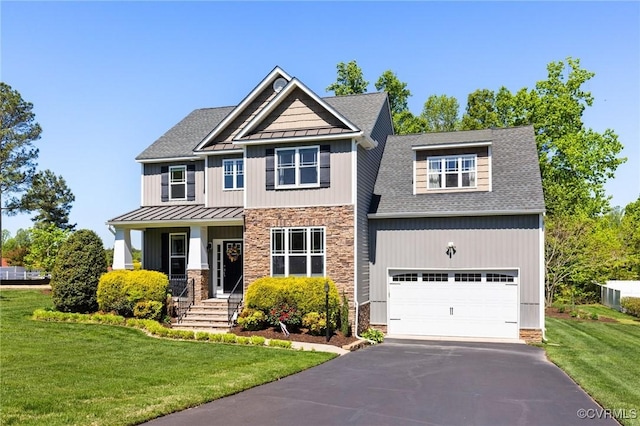 craftsman-style house with a front yard, stone siding, a standing seam roof, metal roof, and driveway