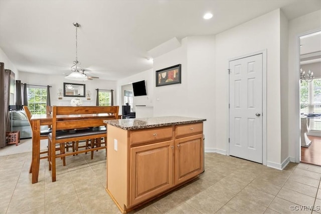 kitchen featuring light tile patterned floors, stone counters, recessed lighting, and a kitchen island