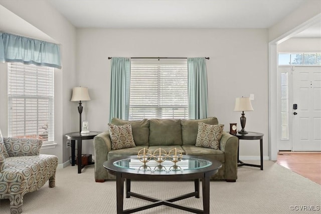 living area with baseboards and light colored carpet