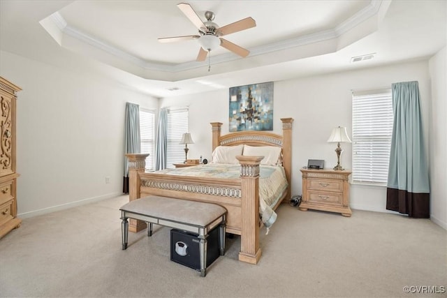 bedroom featuring light colored carpet, visible vents, a raised ceiling, ceiling fan, and ornamental molding