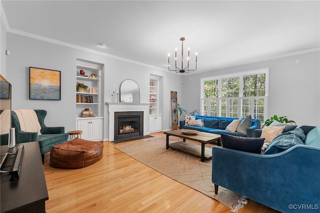living room with crown molding, a chandelier, and wood finished floors