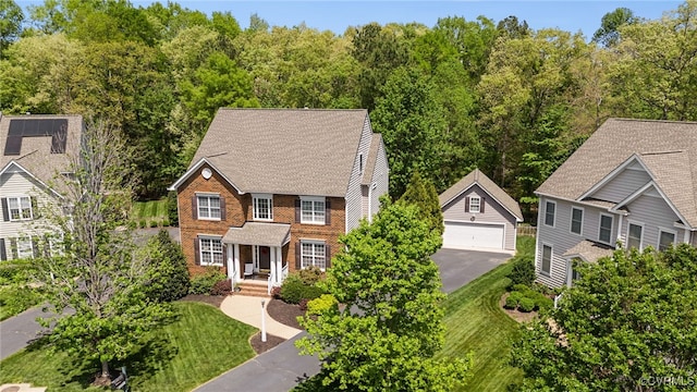 view of front of property featuring a detached garage, brick siding, and an outdoor structure