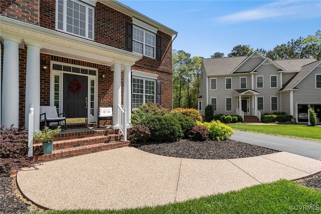view of front of home featuring covered porch and brick siding