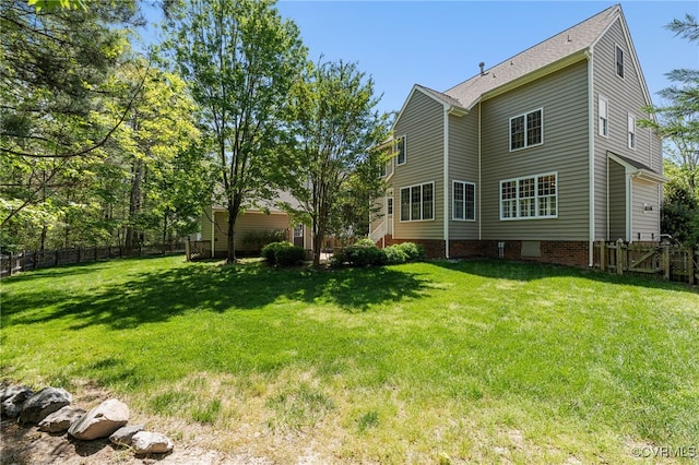 back of property featuring fence and a yard