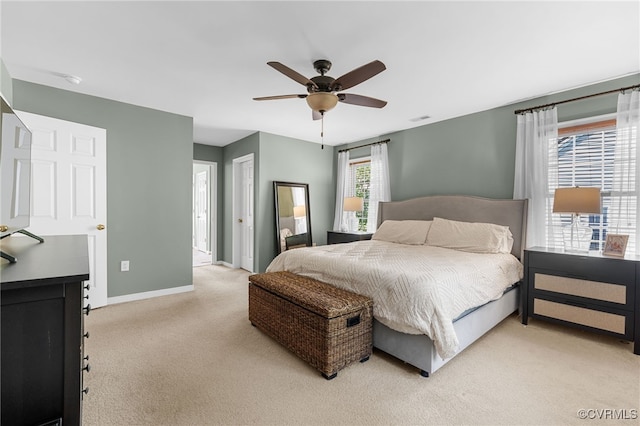 bedroom with baseboards, light carpet, a ceiling fan, and visible vents