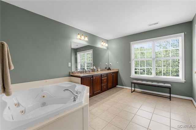 full bathroom with double vanity, tile patterned floors, plenty of natural light, and a tub with jets