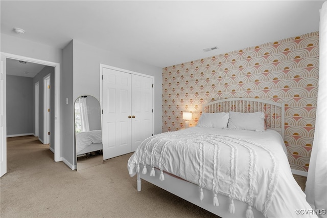 carpeted bedroom with baseboards, visible vents, and a closet
