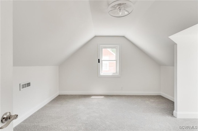 additional living space with baseboards, carpet flooring, lofted ceiling, and visible vents