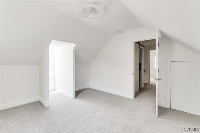 bonus room with light colored carpet, baseboards, and lofted ceiling