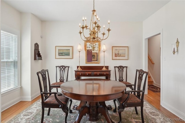 dining area featuring a healthy amount of sunlight, baseboards, a chandelier, and light wood-type flooring