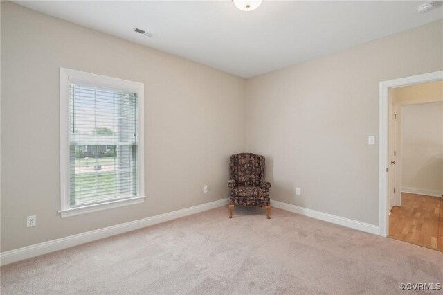 unfurnished room with baseboards, visible vents, a wealth of natural light, and carpet flooring
