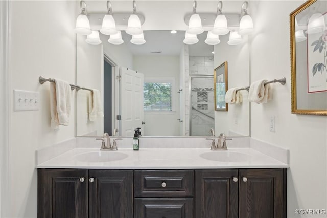 bathroom with a shower stall, double vanity, and a sink