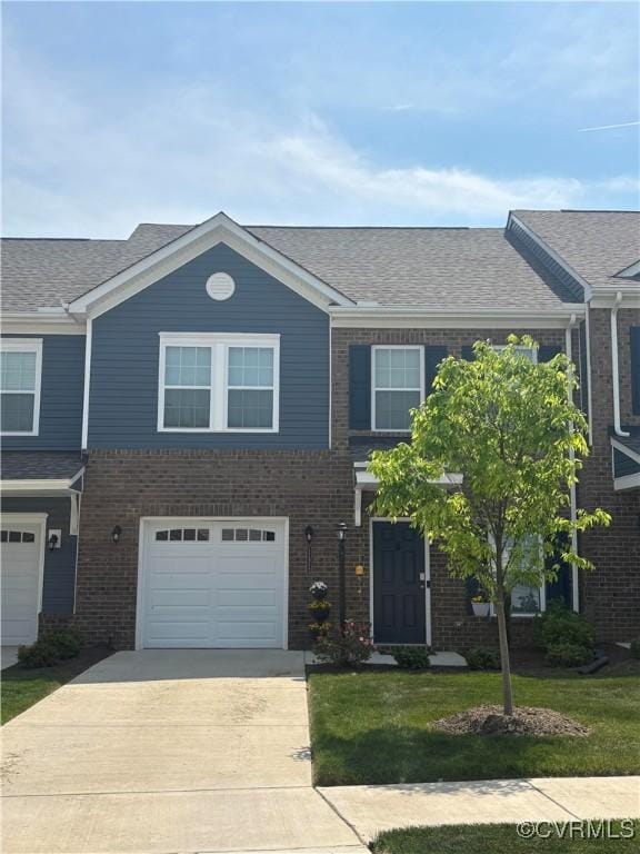 townhome / multi-family property featuring driveway, a garage, brick siding, a front lawn, and a shingled roof