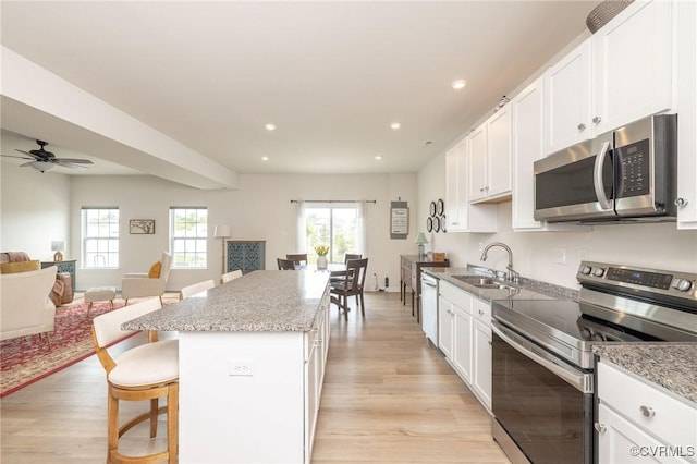 11513 Dunmore Mill Ter Unit 3-4, Chester, VA 23831 - kitchen featuring a sink, a center island, stainless steel appliances, open floor plan, and light wood-type flooring