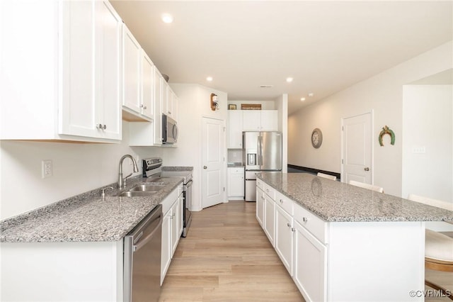11513 Dunmore Mill Ter Unit 3-4, Chester, VA 23831 - kitchen with a breakfast bar, a sink, light wood finished floors, a center island, and stainless steel appliances