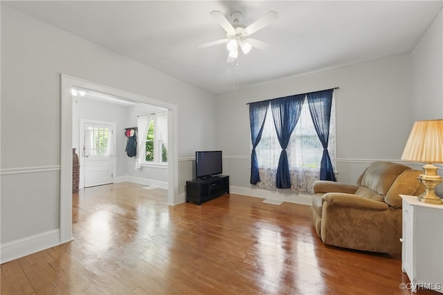 living room with wood finished floors, ceiling fan, and baseboards