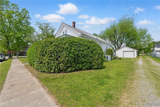 view of property exterior featuring central AC unit, an outbuilding, a detached garage, a lawn, and a chimney