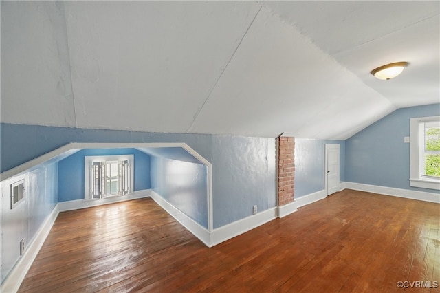 bonus room with hardwood / wood-style floors, lofted ceiling, and baseboards