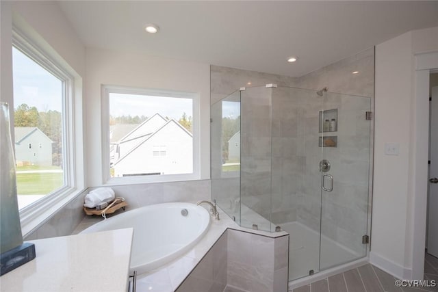 full bathroom with a garden tub, recessed lighting, and a shower stall