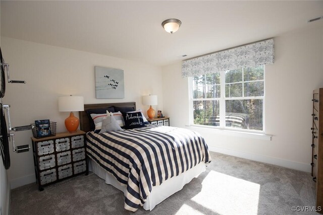 bedroom with baseboards, visible vents, and carpet