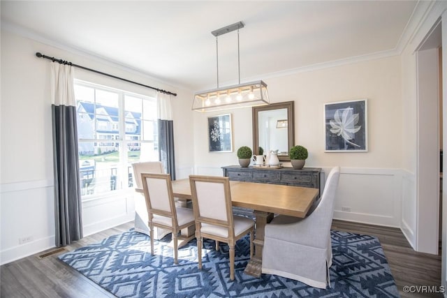 dining room with ornamental molding, dark wood-style flooring, wainscoting, and visible vents