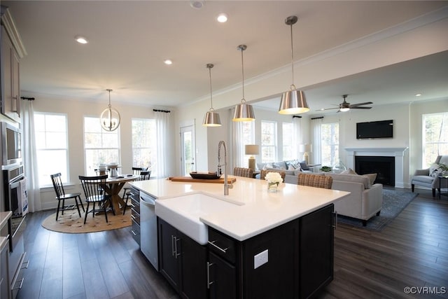 kitchen with light countertops, dark wood-style flooring, a fireplace, and a sink