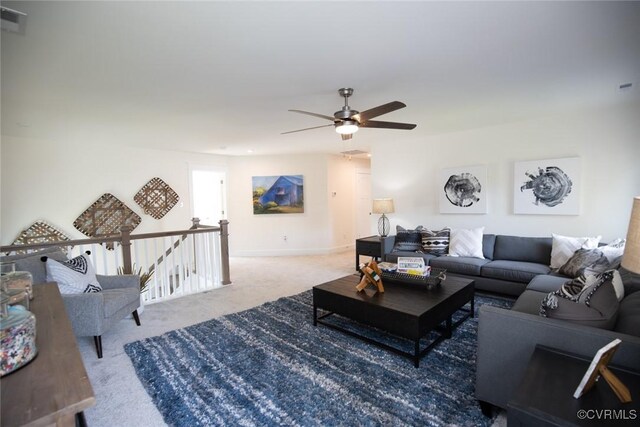 living area with visible vents, a ceiling fan, and carpet floors