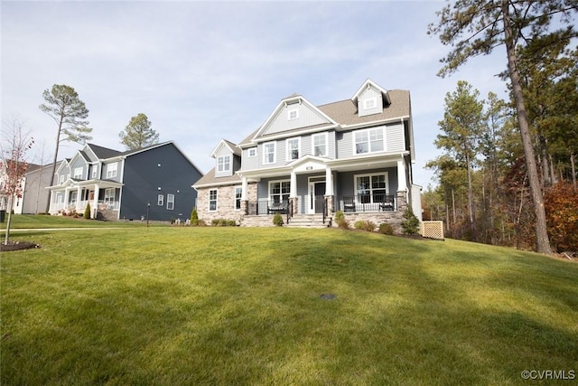 craftsman inspired home featuring covered porch, a front yard, and stone siding