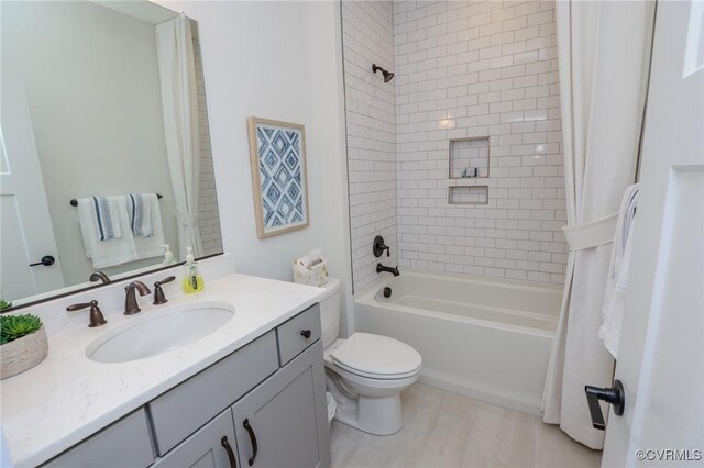 bathroom with shower / bath combo with shower curtain, toilet, and vanity