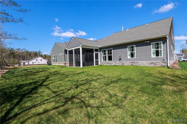rear view of property with a sunroom and a lawn
