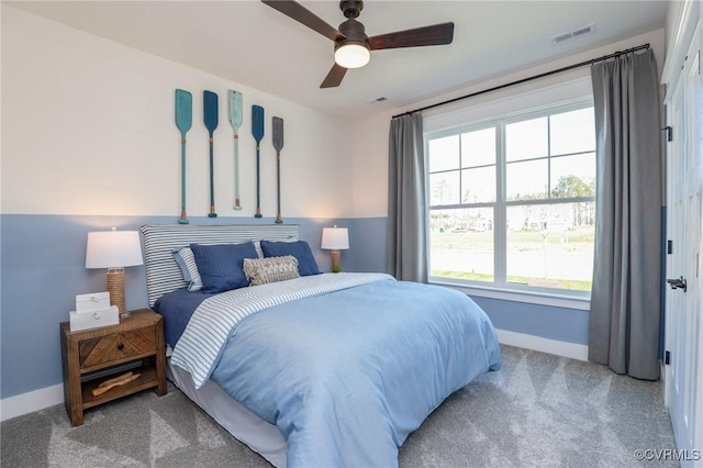 carpeted bedroom featuring baseboards, visible vents, and a ceiling fan