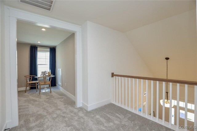 hallway with baseboards, visible vents, and carpet flooring