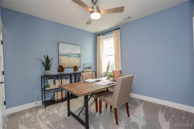home office with carpet flooring, a ceiling fan, visible vents, and baseboards
