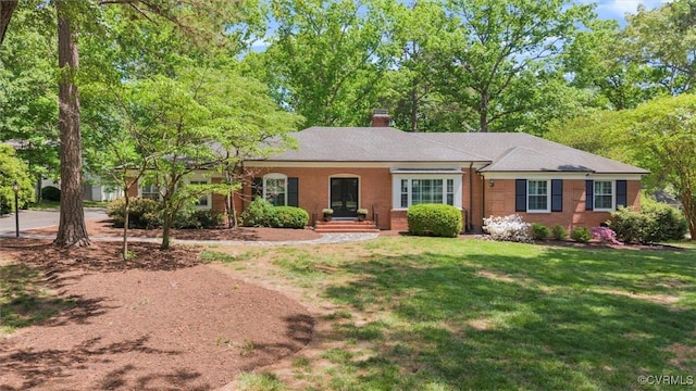 ranch-style house with brick siding, a chimney, and a front lawn