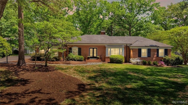 ranch-style house featuring brick siding, a front lawn, and a chimney