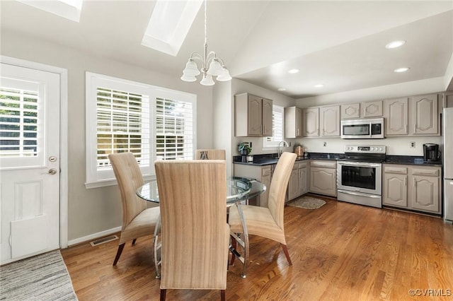 11740 Park Forest Ct, Glen Allen, VA 23059 - dining room with a chandelier, a wealth of natural light, visible vents, and vaulted ceiling with skylight