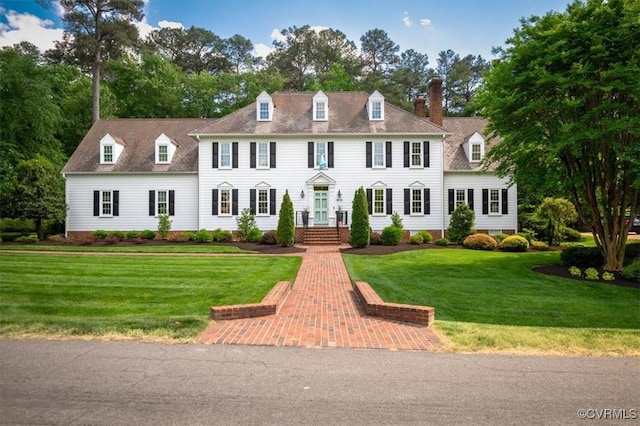 view of front of home with a chimney and a front yard