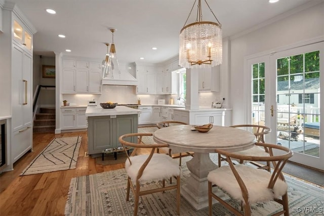dining area featuring french doors, recessed lighting, a chandelier, crown molding, and light wood-type flooring